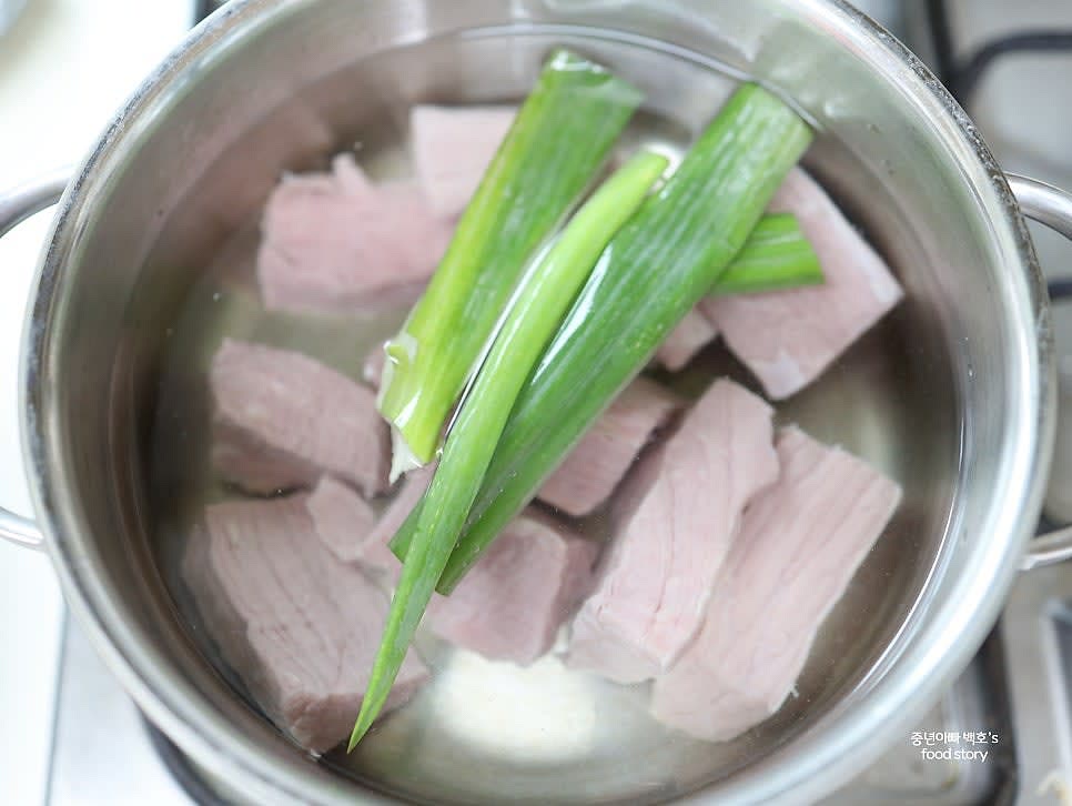 냄비에 물 1500ml와 대파 1/2대를 넣고 센 불에서 10분간 팔팔 끓여 고기를 삶습니다. 거품은 채망으로 걷어냅니다.