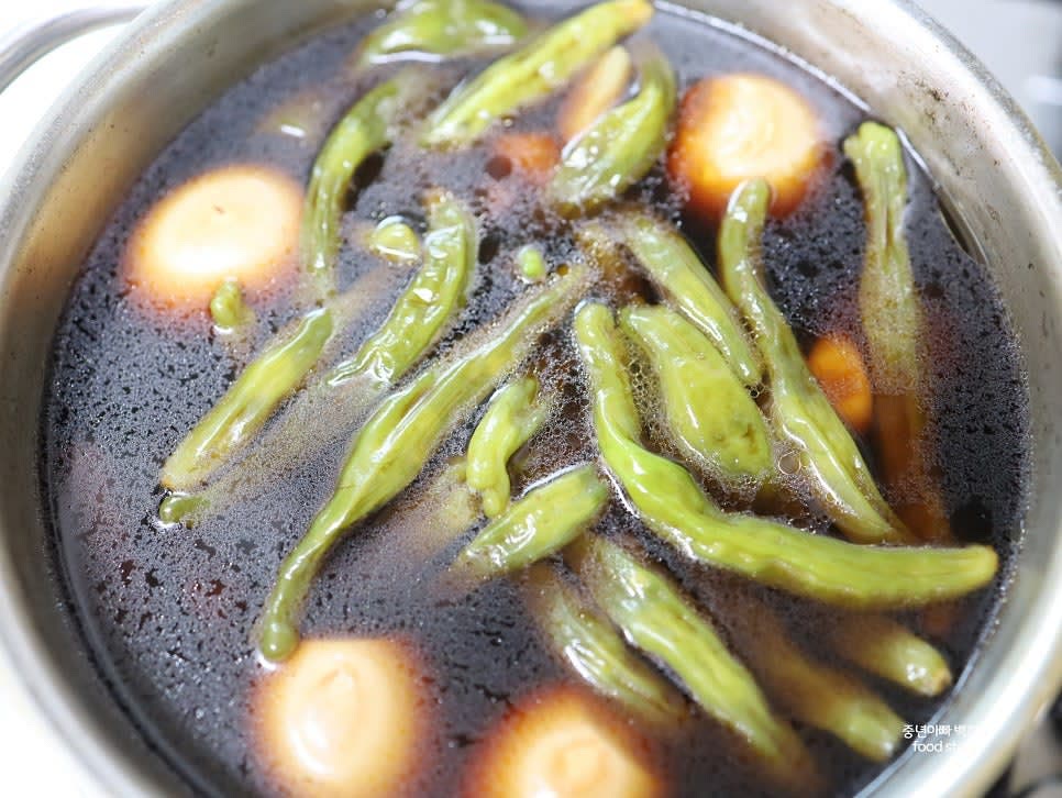 삶은 달걀 12알과 가운데 포크로 구멍을 낸 꽈리고추 20개를 넣어 센 불에서 한 번 팔팔 끓입니다.