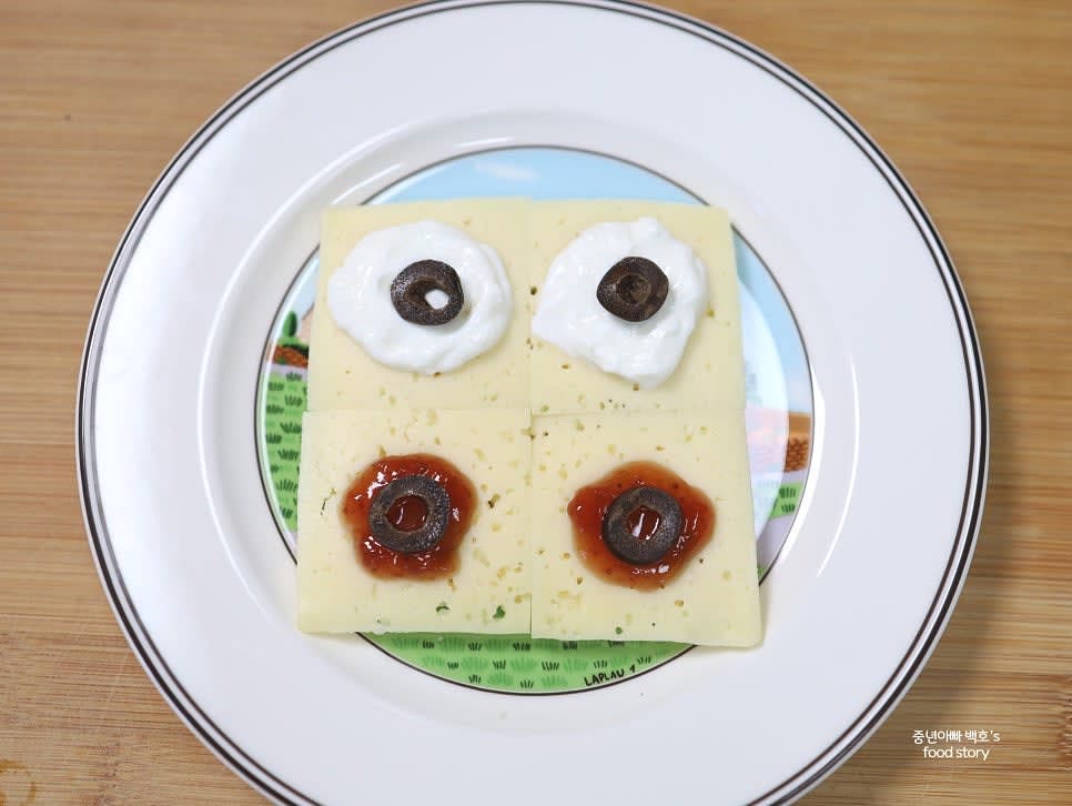 블랙 올리브를 얇게 썰어 모든 크래커 위에 올려 포인트를 줍니다.