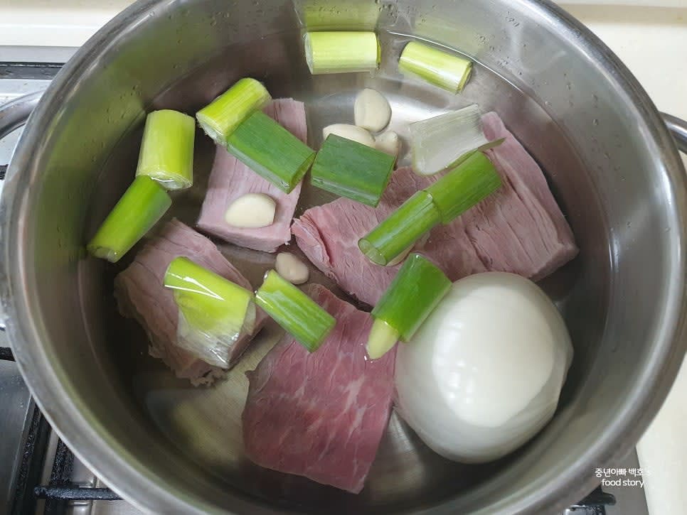 냄비에 생수 1.5리터를 붓고 우둔살, 대파, 양파, 통마늘을 넣은 후 센 불에서 끓입니다.
