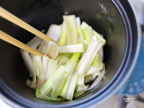 냄비에 식용유 2스푼과 참기름 3스푼을 넣고 중불에서 대파를 볶아 향을 냅니다.