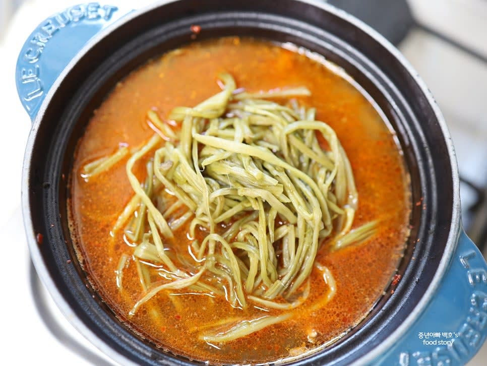 고구마 줄기와 다진 마늘 1스푼, 국간장 1스푼, 연두 2스푼을 넣고 센 불에서 끓입니다.