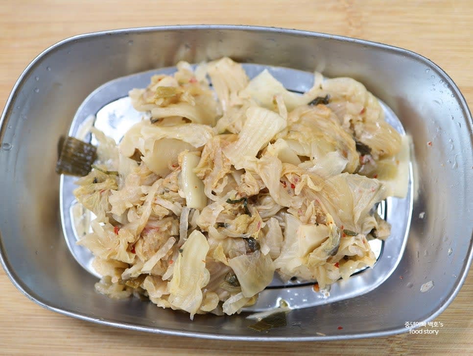 묵은지를 찬물에 깨끗이 씻으며 양념을 털어내고 물기를 짜서 준비합니다.