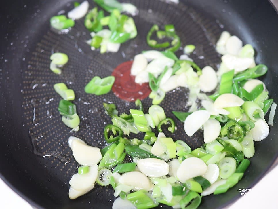 파향이 올라오면 통마늘과 청양고추를 넣고 볶아줍니다.