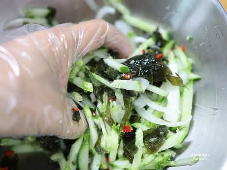 볼에 미역, 오이, 양파, 고추를 넣고 다진 마늘 1/2스푼, 국간장 1/2스푼, 소금을 적당량 넣어 조물조물 무쳐줍니다.