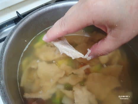 숙성된 수제비반죽을 얇게 펴 손으로 적당한 크기로 떼어내며 국물에 넣습니다. 중간중간 저어주어 서로 붙지 않도록 합니다.