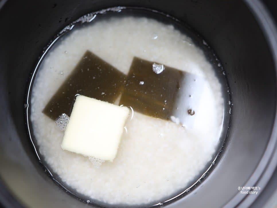 흰쌀 2컵을 씻어 무쇠솥에 넣고 물 2컵을 붓습니다. 가염버터 1조각과 다시마 2장을 넣어 줍니다.