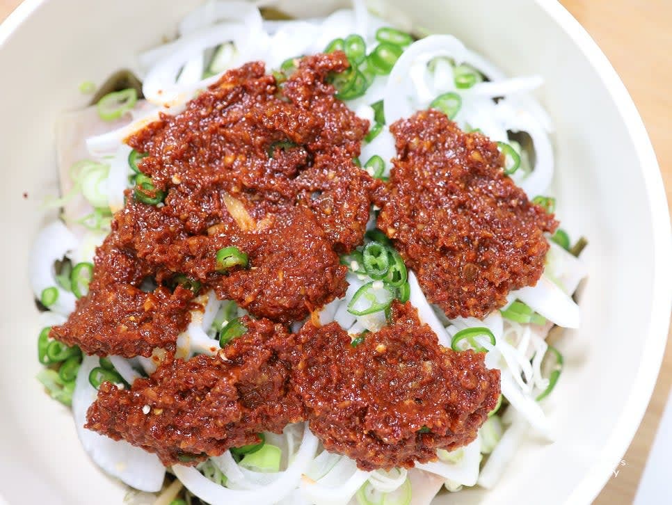 냄비에 묵은지를 깔고 고등어를 올린 뒤 양파, 대파, 청양고추를 순서대로 얹습니다.