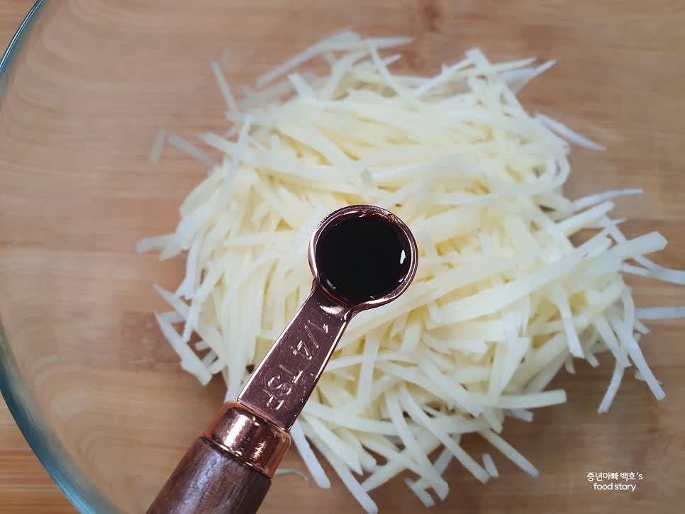 그릇에 감자를 담고 국간장 1/4티스푼, 다진 마늘 1/4티스푼, 다진 파 1/3수저, 소금 조금, 참기름 1/2수저, 통깨 약간을 넣고 손으로 조물조물 무쳐줍니다.