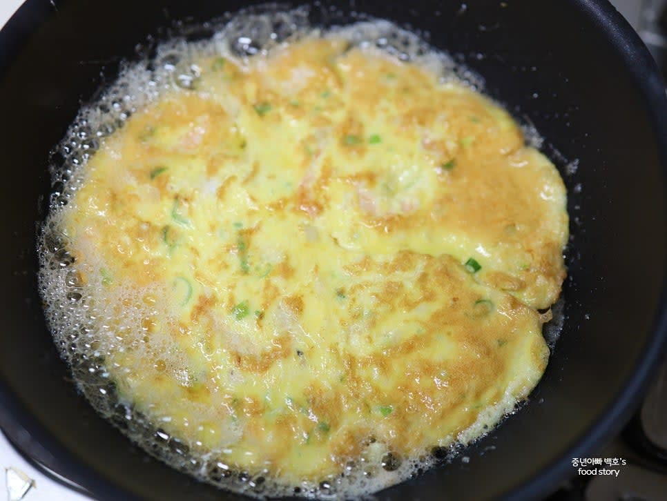 팬에 식용유를 두르고 계란물을 부어 동그란 모양으로 부칩니다. 앞뒤로 노릇하게 익힌 후 밥 위에 올립니다.