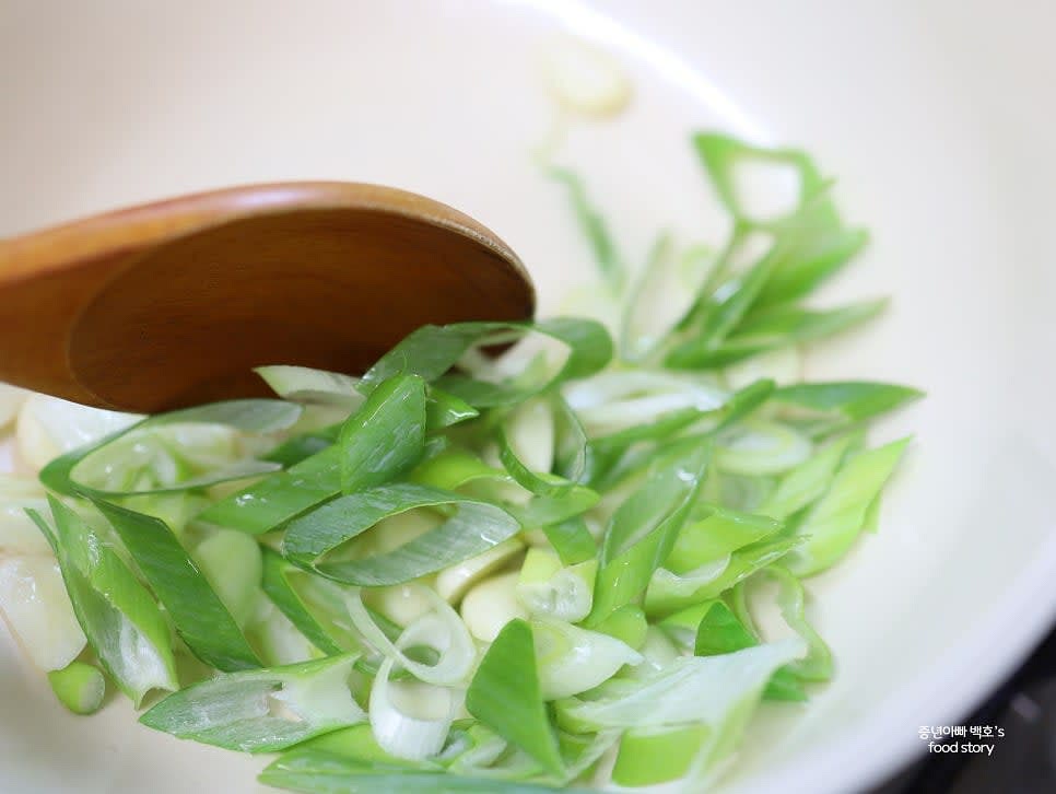 팬에 식용유 3스푼을 두르고 중약불에서 통마늘과 대파를 볶아 향을 냅니다.