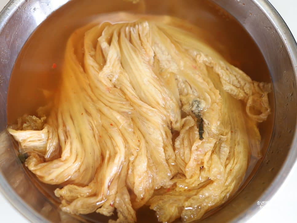 신김치를 흐르는 물에 깨끗이 씻어 속 양념을 제거하고, 최소 1시간 이상 물에 담가 쓴맛과 간을 빼줍니다.