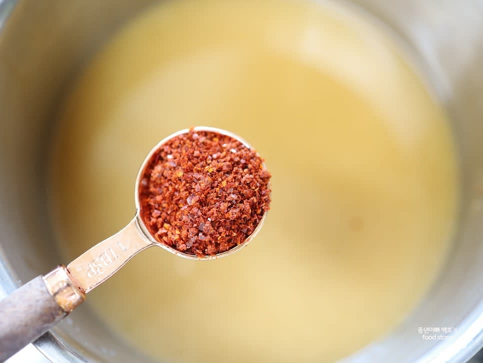 고춧가루 1스푼을 넣고 씻은 신김치를 넣은 후, 생수 1컵을 추가합니다.