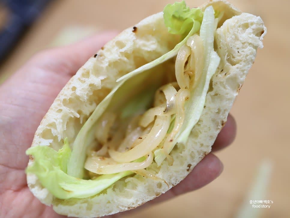 피타 브레드 안에 양상추를 먼저 깔고, 볶은 양파와 불고기를 적당히 채워 넣습니다.