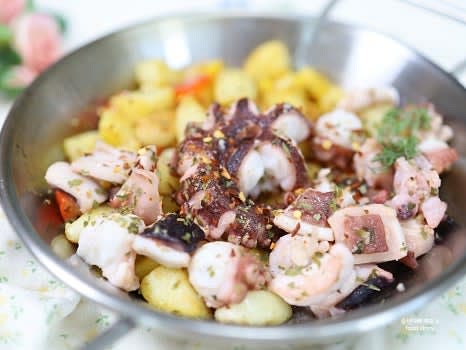 감자와 문어를 그릇에 담고, 크러쉬드 레드 페퍼와 후추를 뿌려 마무리합니다.