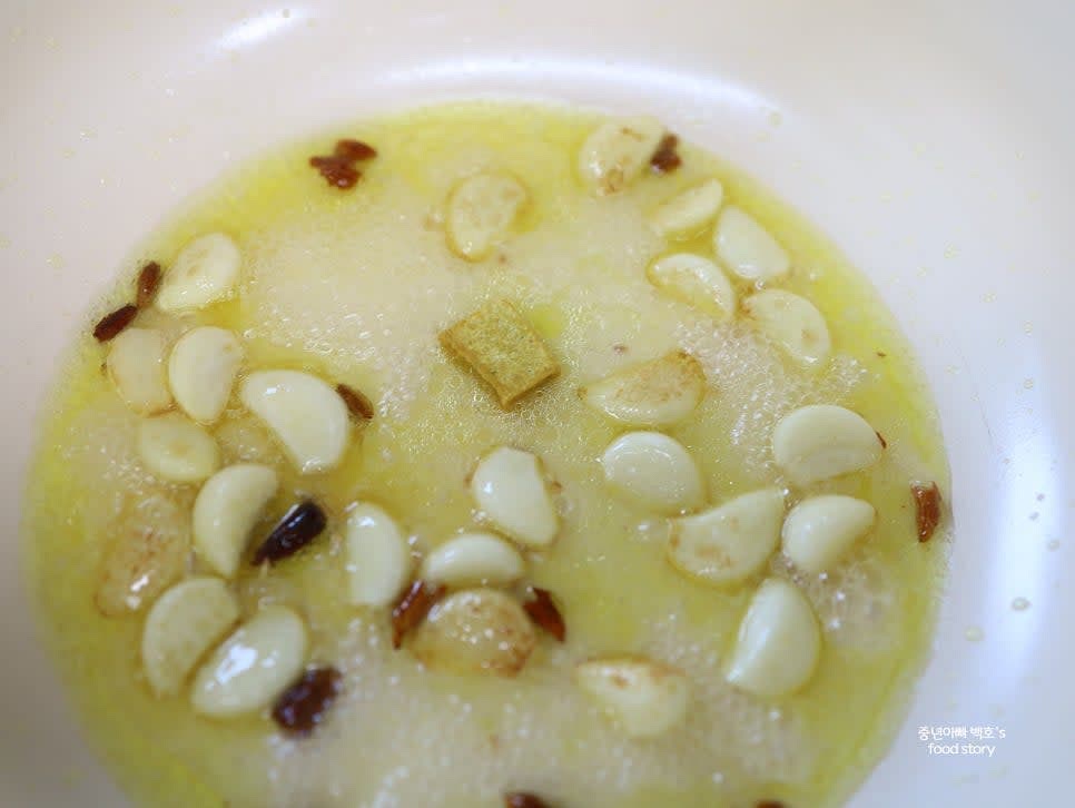 마늘이 반 정도 익으면 치킨스톡을 넣고 1~2분 끓여줍니다. 면수를 반컵 추가하여 끓입니다.