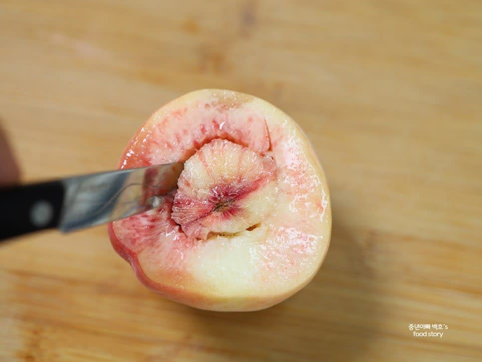 칼을 사용해 복숭아 씨 주변을 빙 둘러 잘라 주고, 수저나 포크로 씨를 조심스럽게 빼냅니다. 바닥이 뚫리지 않도록 주의합니다.