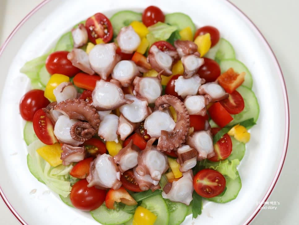 접시에 양상추를 깔고, 오이와 깻잎, 방울토마토, 파프리카를 차례로 올린 뒤, 문어를 얹습니다.