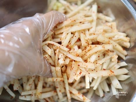 손으로 무를 골고루 무치며 고춧가루가 잘 배이도록 섞어줍니다.