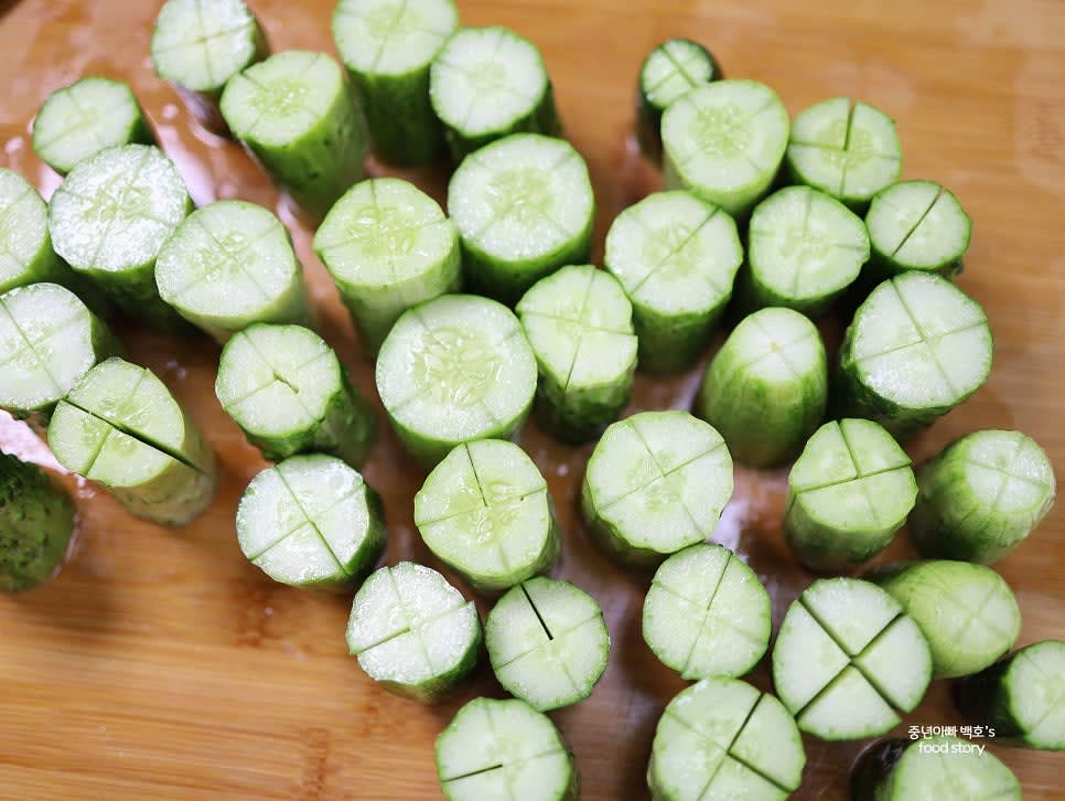 오이의 양 끝을 자르고, 4등분으로 자른 뒤 각 조각에 1cm 정도 남기고 십자 칼집을 넣습니다.