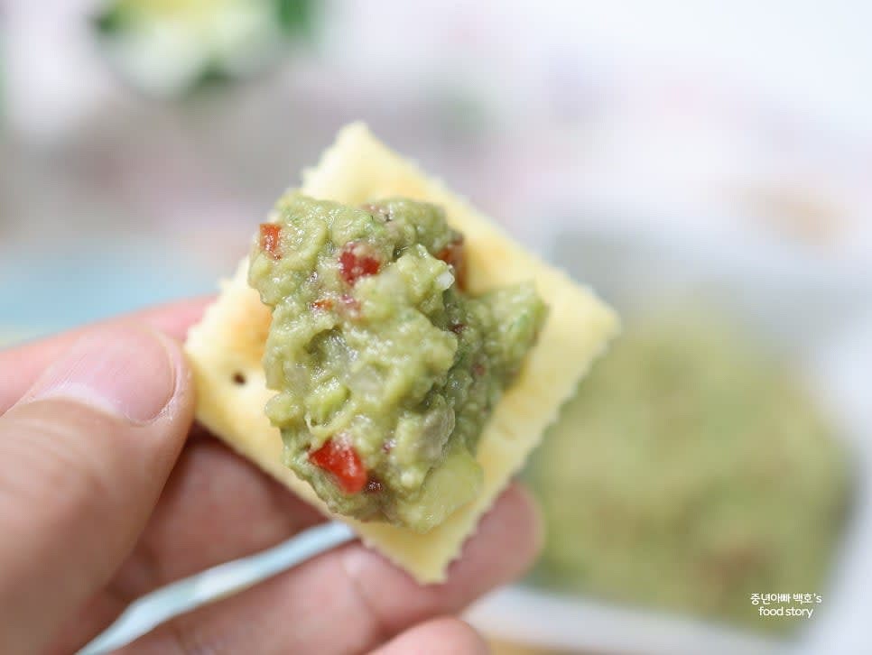 완성된 과카몰리를 그릇에 담고 크래커, 또띠아 칩, 빵 등에 곁들여 서빙합니다.