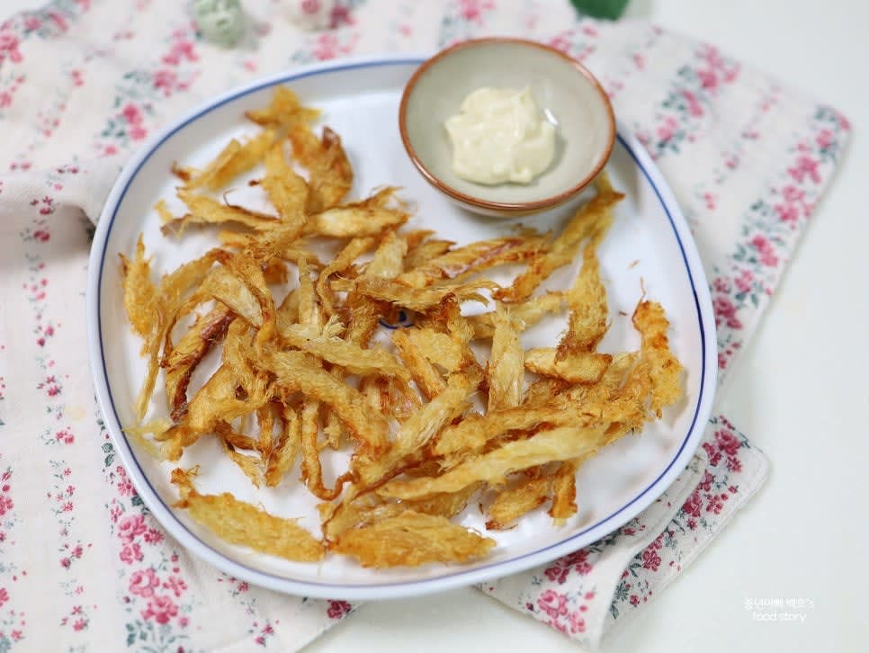 구워진 황태채를 접시에 담고 와사비마요네즈 소스를 곁들여 서빙합니다.