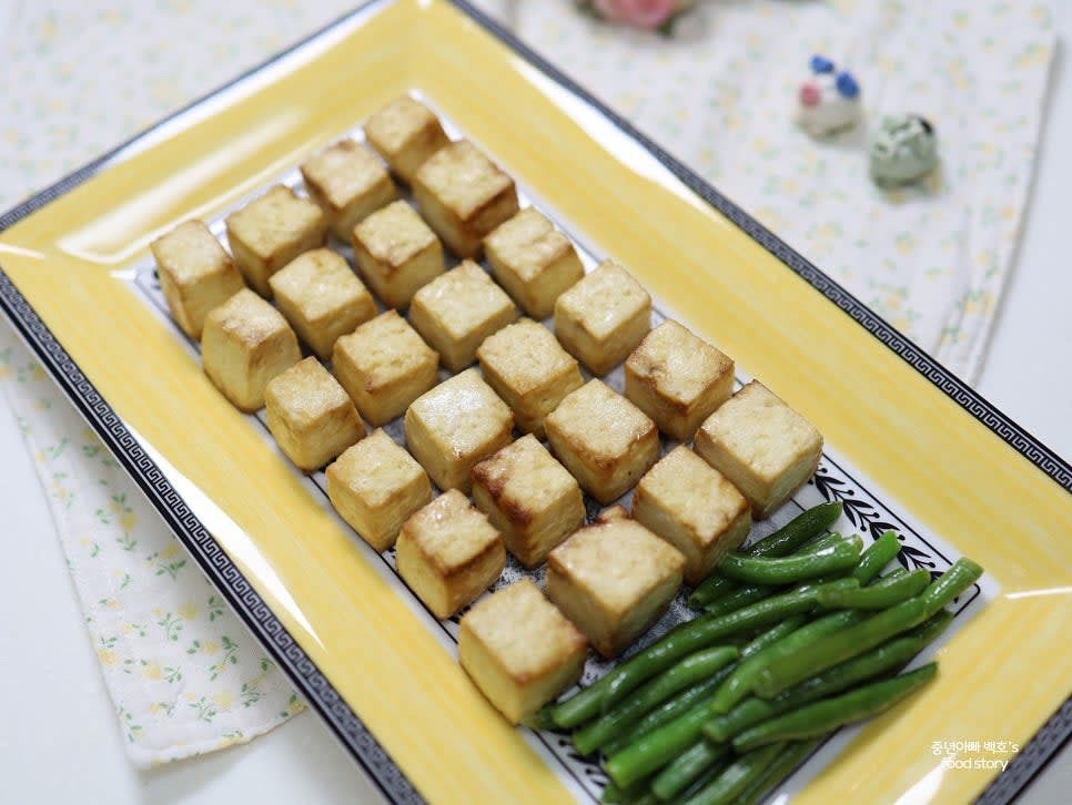 완성된 두부스테이크를 그린빈스와 함께 접시에 담아 제공합니다.