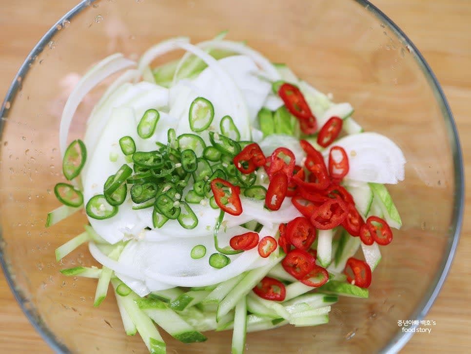 채 썬 오이와 양파, 고추를 큰 그릇에 담고 국간장 1/2스푼, 다진 마늘 1/2스푼, 소금 약간을 넣어 조물조물 무칩니다.