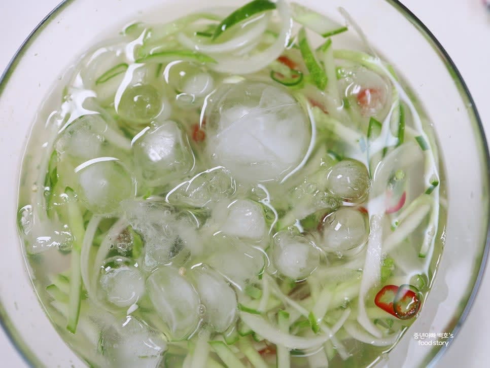 무친 재료에 육수를 붓고 얼음을 듬뿍 넣어줍니다. 간이 부족하다면 소금이나 식초를 추가합니다.