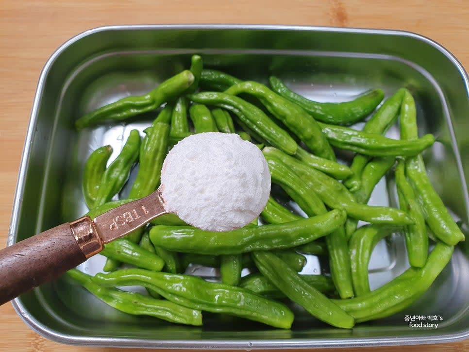 꽈리고추 3컵 분량에 쌀가루 2스푼을 넣고 골고루 버무립니다.