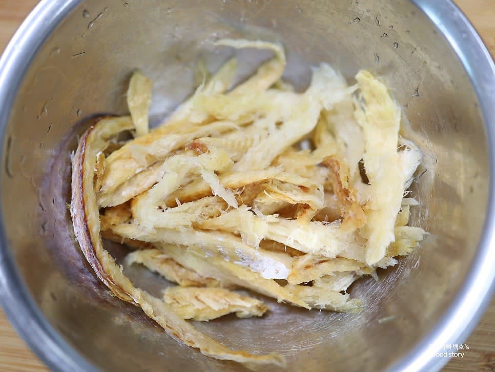 황태채를 물에 적셔 가볍게 헹군 후 물기를 짜고 가시를 제거합니다. 먹기 좋은 크기로 손이나 가위로 자릅니다.