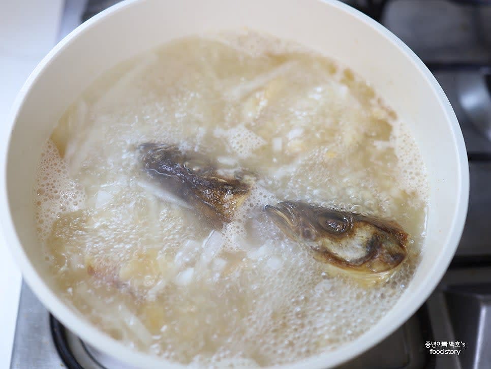 생수 500ml를 먼저 붓고 머리를 넣어 국물이 자작하게 끓도록 합니다. 팔팔 끓여 국물이 뽀얗게 우러나면 생수 1000ml를 추가로 붓습니다.