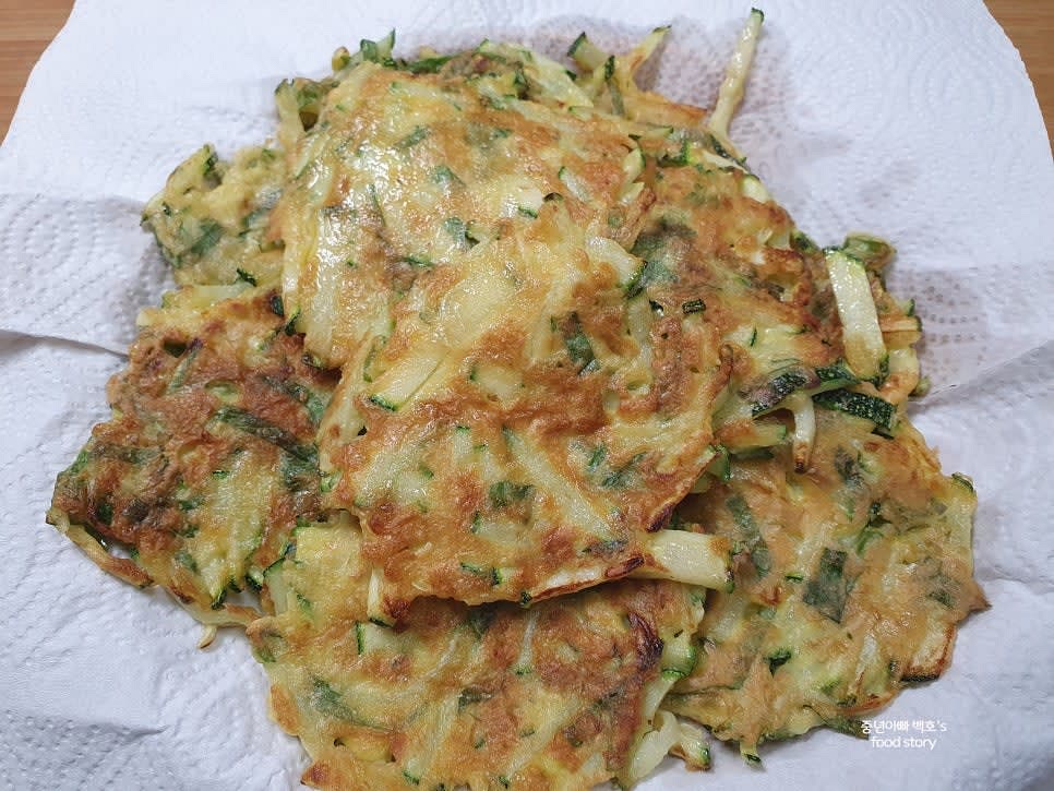 노릇하게 익힌 호박전을 키친타월에 올려 기름을 뺀 후 접시에 담습니다.