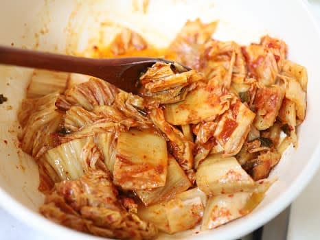 팬에 참기름 2스푼을 넣고 묵은지를 넣어 숨이 죽을 때까지 볶아줍니다.