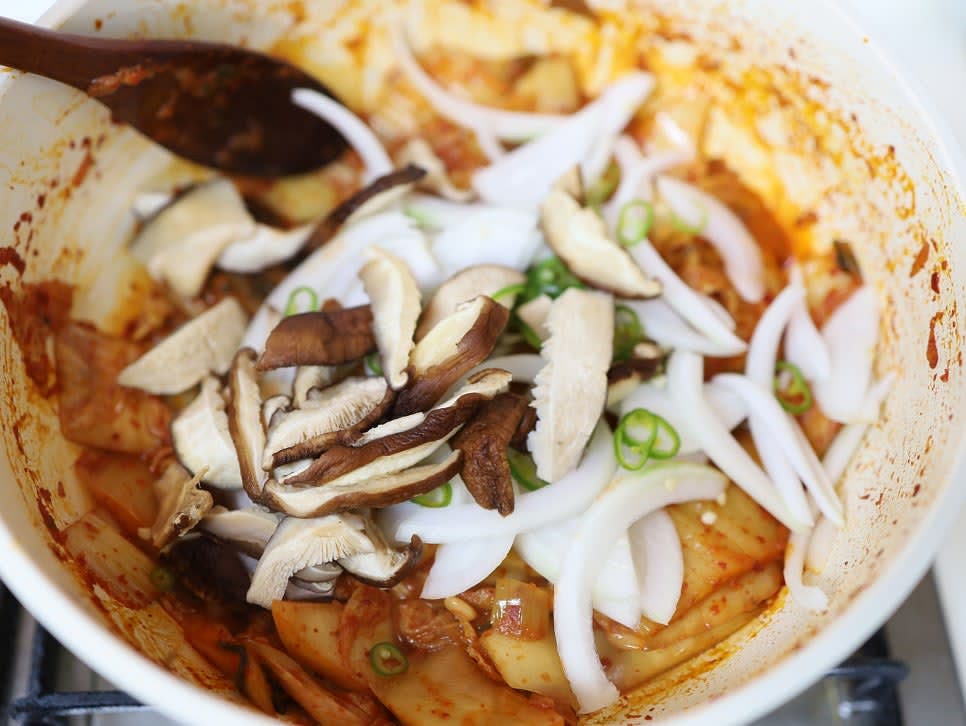 볶아진 묵은지에 양파, 청양고추, 불린 표고버섯을 추가하고 골고루 섞어줍니다.