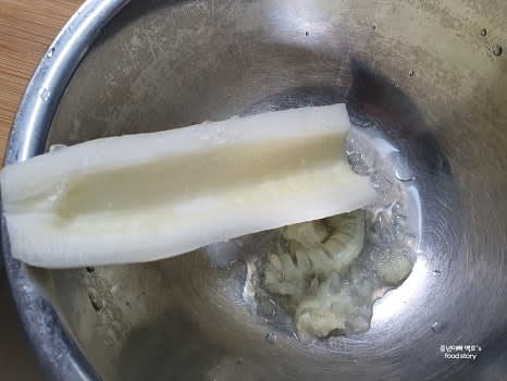 노각을 길게 반으로 자른 후 속의 씨를 수저로 깨끗이 긁어냅니다.