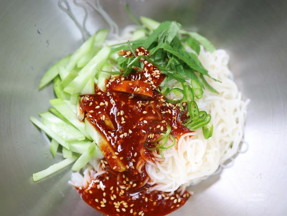 그릇에 소면을 담고 오이, 깻잎, 청양고추를 일부 넣은 뒤 양념장을 넣고 골고루 버무립니다.