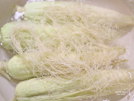 옥수수를 냄비에 올린 후 위에 남은 옥수수 잎과 수염을 덮어줍니다.