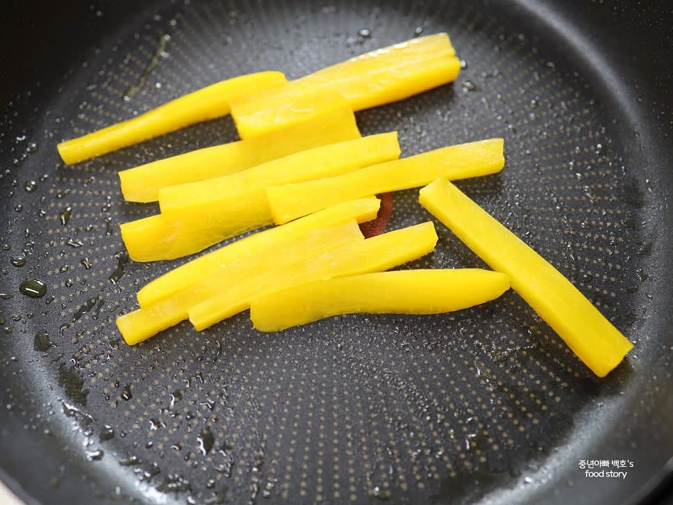 단무지는 길이에 맞게 자르고, 팬에서 살짝 볶아 고소한 맛을 더합니다.