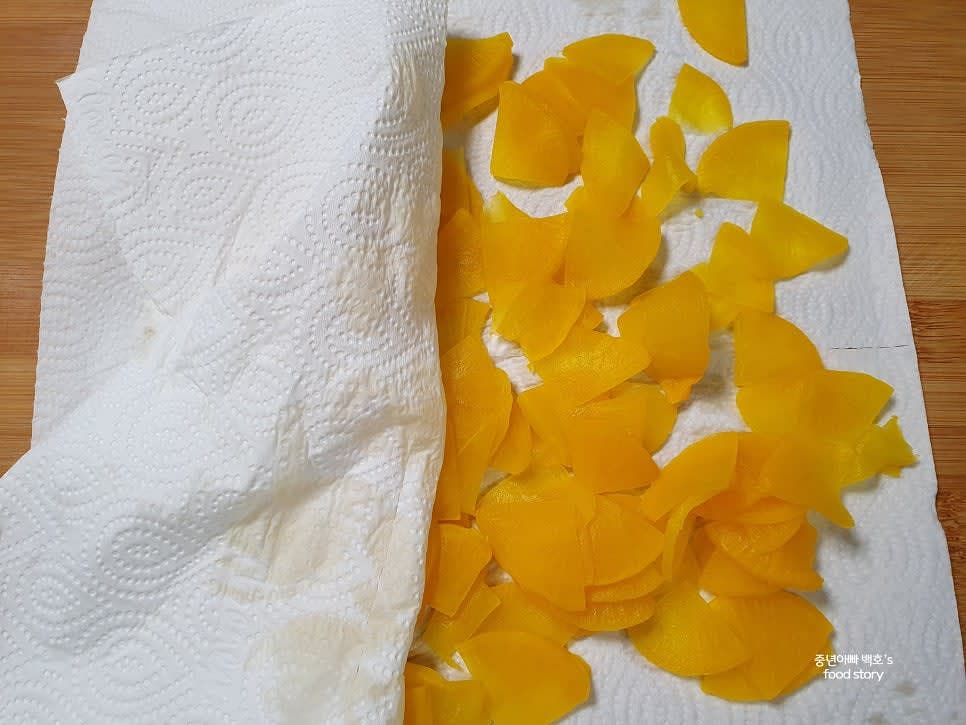 단무지를 원하는 모양과 크기로 얇게 썰어줍니다. 꼬들꼬들한 식감을 원하면 물기를 더 꽉 짜주세요.
