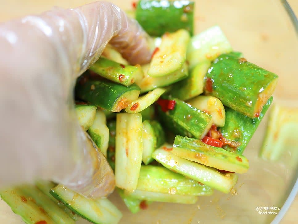 오이와 홍고추를 그릇에 담고, 양념장을 1스푼 넣고 골고루 버무립니다. 부족하면 양념장을 추가합니다.