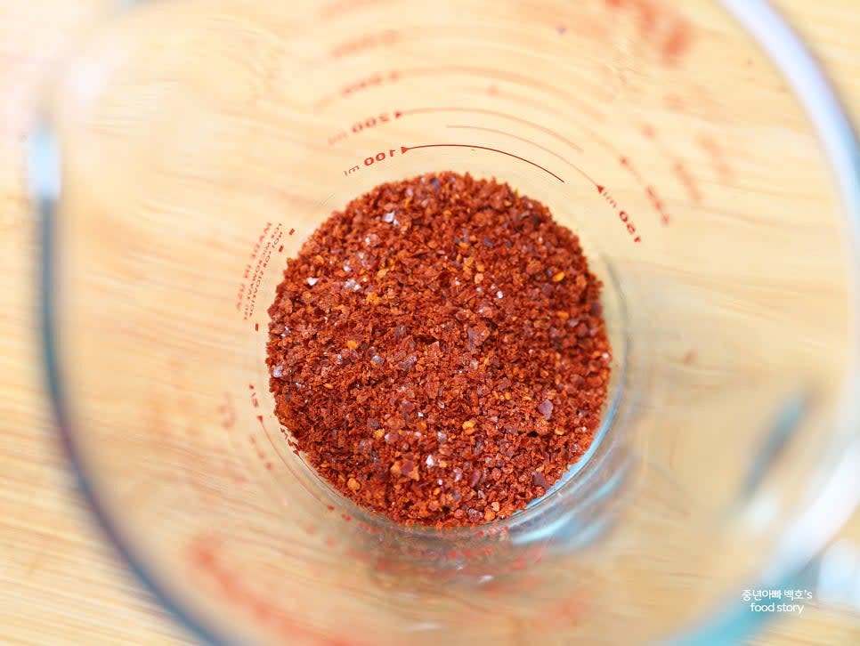 전자레인지 사용 가능한 높이가 있는 그릇에 고춧가루 5스푼을 넣습니다.