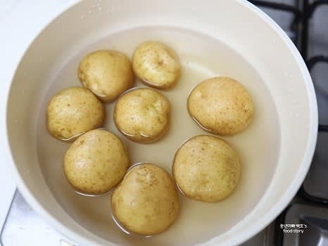 냄비에 감자를 한 층으로 넣고, 물을 2/3 정도 잠길 만큼 부어주세요.