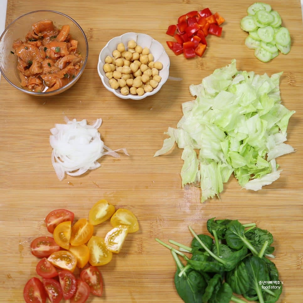 채소를 준비합니다. 양파는 얇게 채썰어 매운맛을 제거하고, 방울토마토는 4등분, 오이와 피망은 한입 크기로 자릅니다. 양상추와 비타민 채소도 적당히 썰어둡니다.