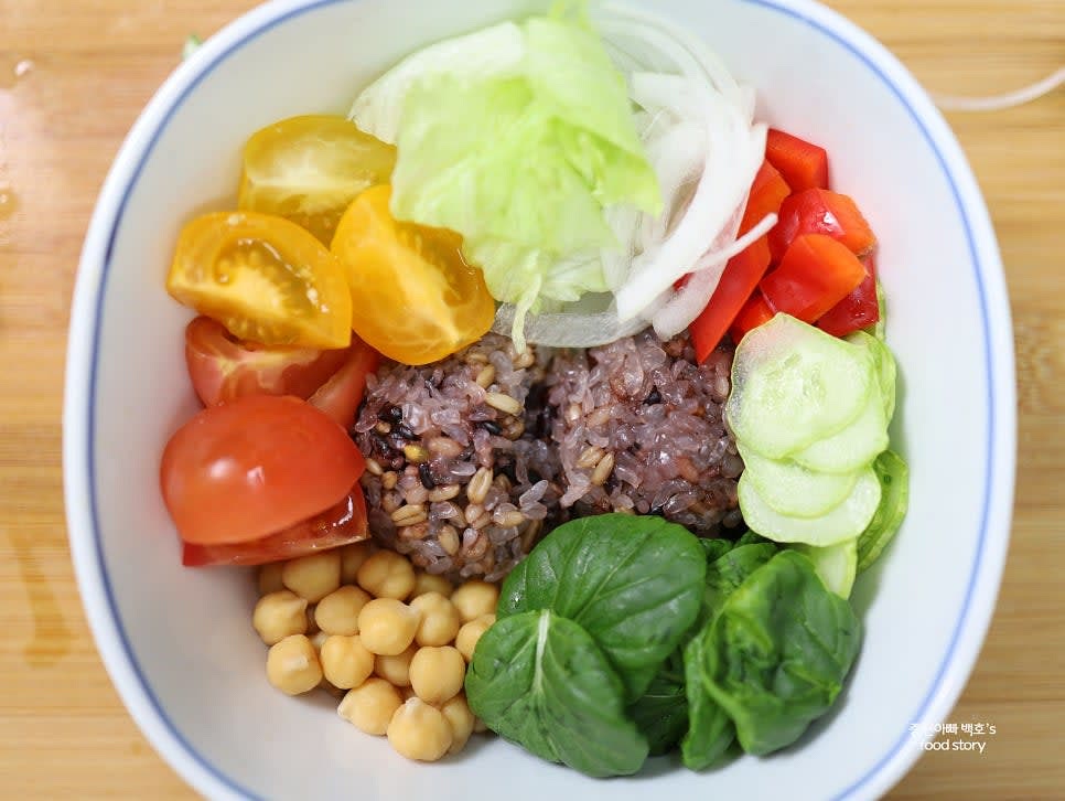 그릇에 밥을 담고 병아리콩과 채소를 골고루 올립니다.