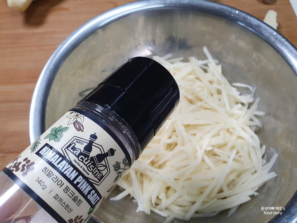 큰 그릇에 감자를 담고 소금을 약간 넣어 섞습니다.