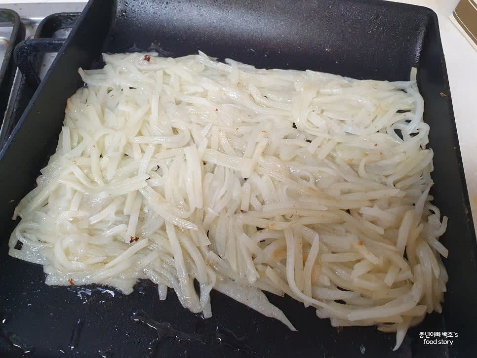 팬에 식용유를 두르고 감자채를 얇게 펴준 후 약불에서 익힙니다.