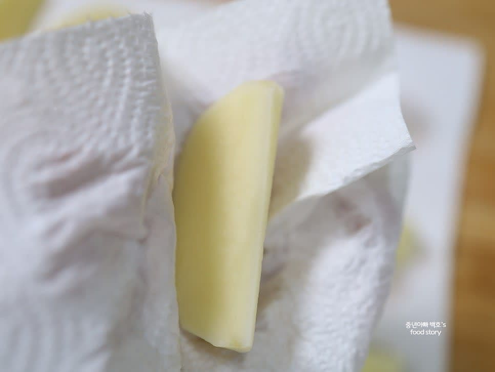 전분을 제거한 감자를 채반에 밭쳐 물기를 제거한 뒤, 키친타월로 한 조각씩 물기를 닦아줍니다.