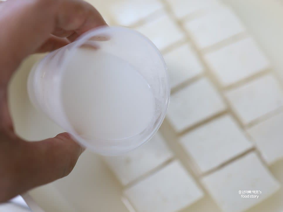 넓은 팬에 두부를 한 줄로 깔고, 쌀뜨물을 두부의 2/3 정도 잠길 만큼 부어줍니다.