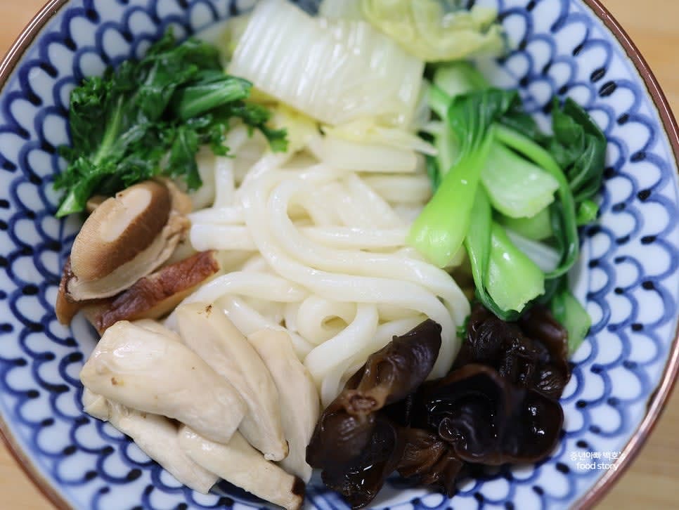 그릇에 우동면을 담고 야채와 버섯을 올린 후 육수를 부어줍니다.